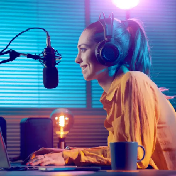A woman with headphones on sitting at a table.