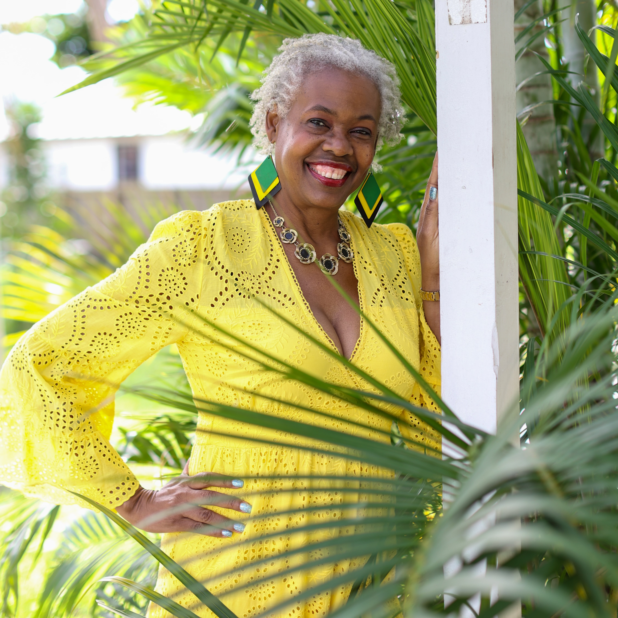 A woman in yellow dress standing next to some trees